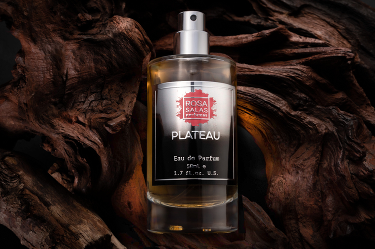 Perfume bottle labeled 'Plateau' by Rosa Salas on a wooden background