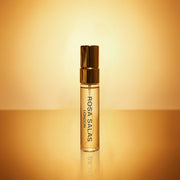 Perfume bottle with gold cap and body on a gradient yellow background