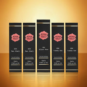 Set of five Rosa Salas perfume bottles on a reflective surface with a warm background