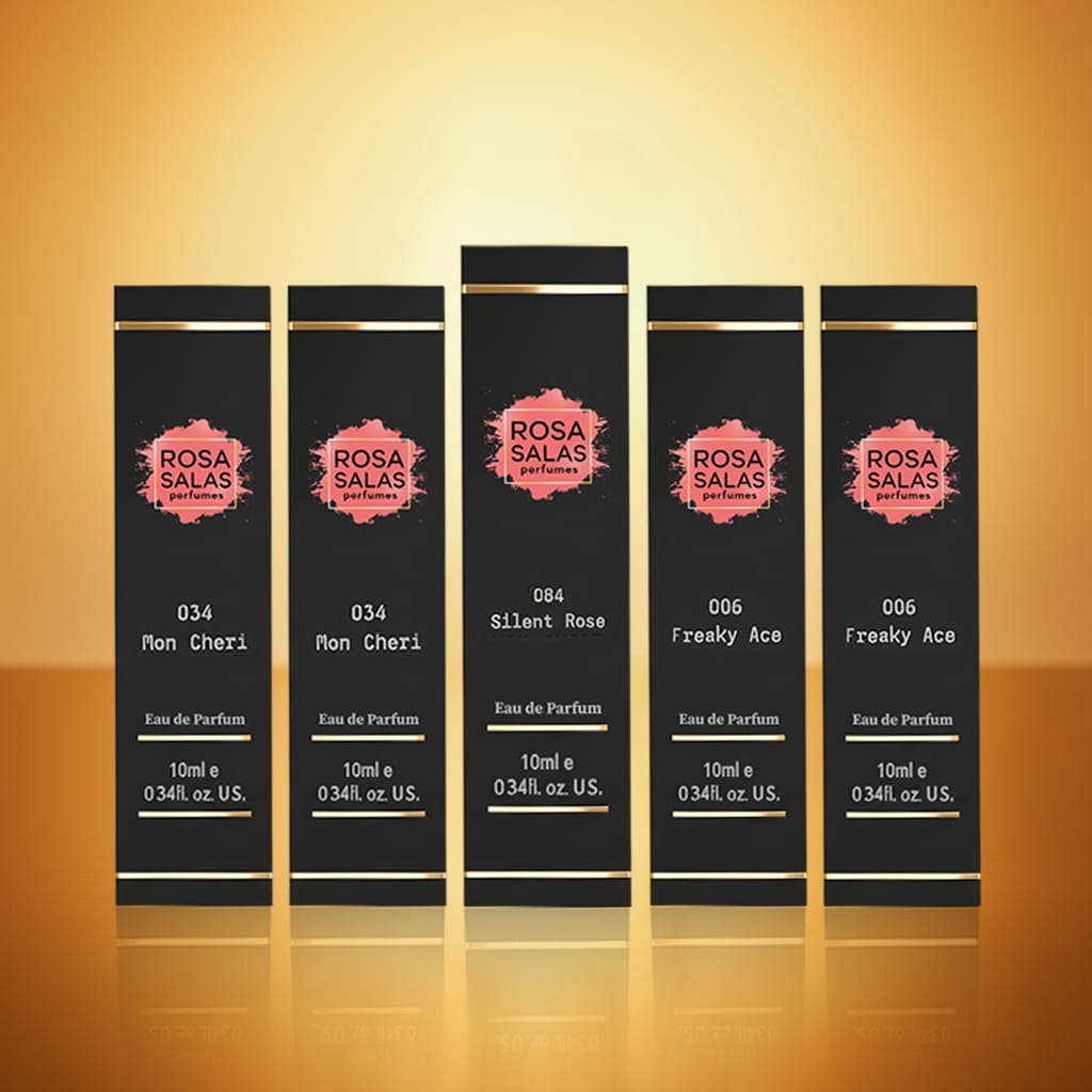 Set of five Rosa Salas perfume bottles on a reflective surface with a warm background