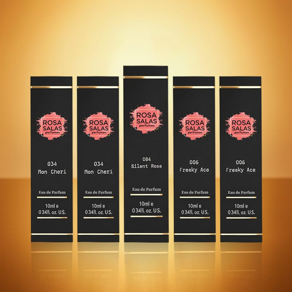 Set of five Rosa Salas perfume bottles on a reflective surface with a warm background