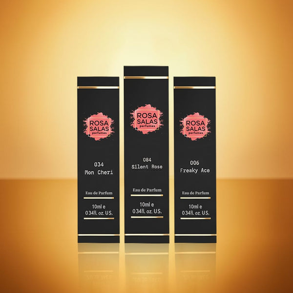 Three black perfume bottles with 'Rosa Salas' branding on a gold gradient background